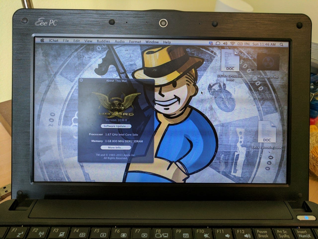 Photo of a netbook screen with a Fallout Boy wallpaper and a "About this Mac" window open, showing it is running Mac OS X 10.6.8